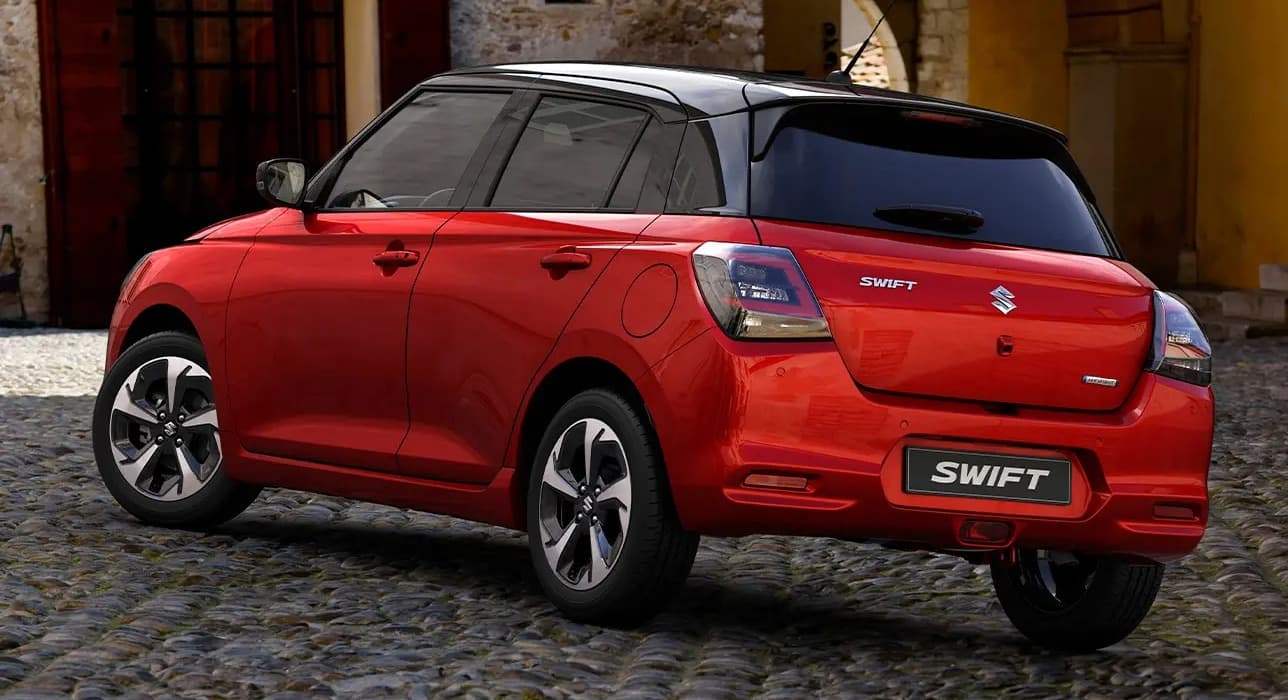 Lángvörös és ónixfekete Suzuki Swift utcai környezetben