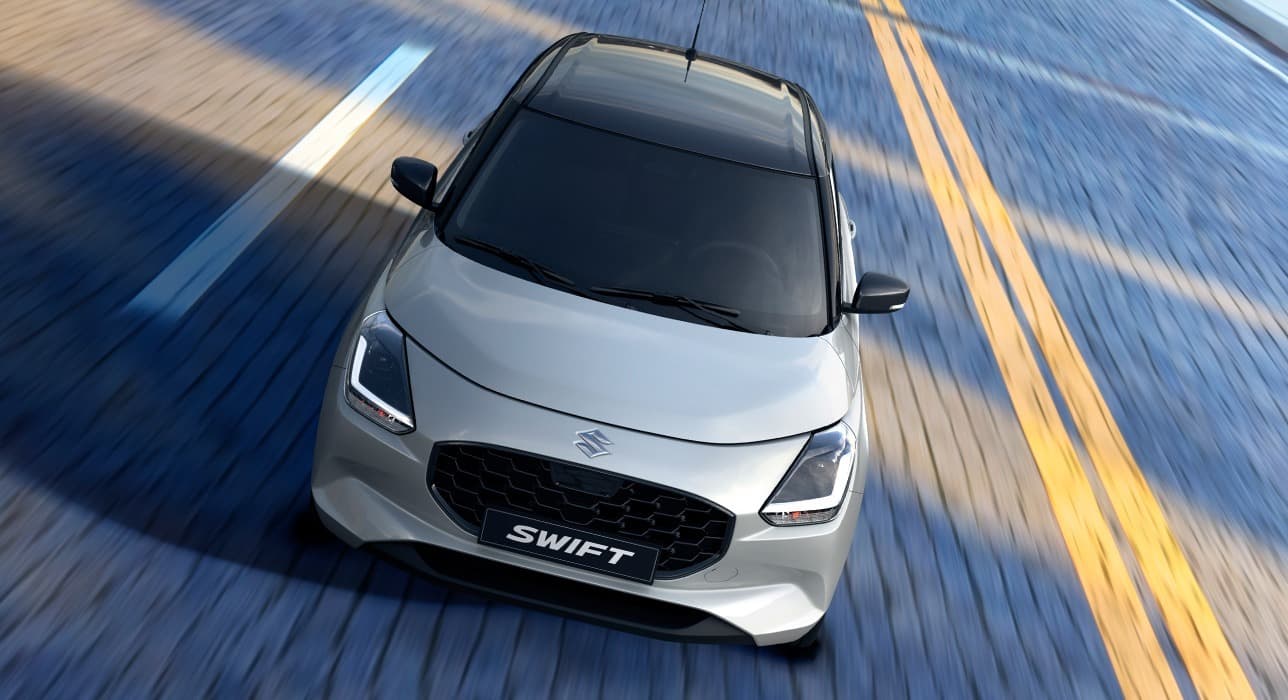 Gleccserfehér és ásványszürke metál Suzuki Swift utcai környezetben