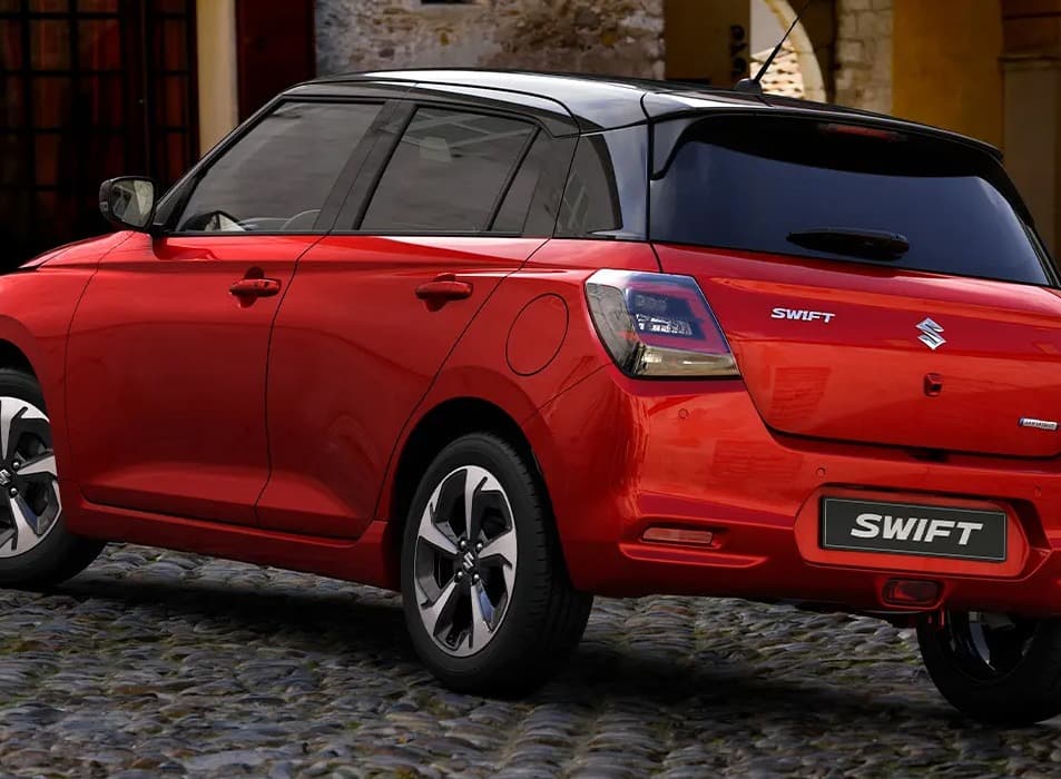 Lángvörös és ónixfekete Suzuki Swift utcai környezetben