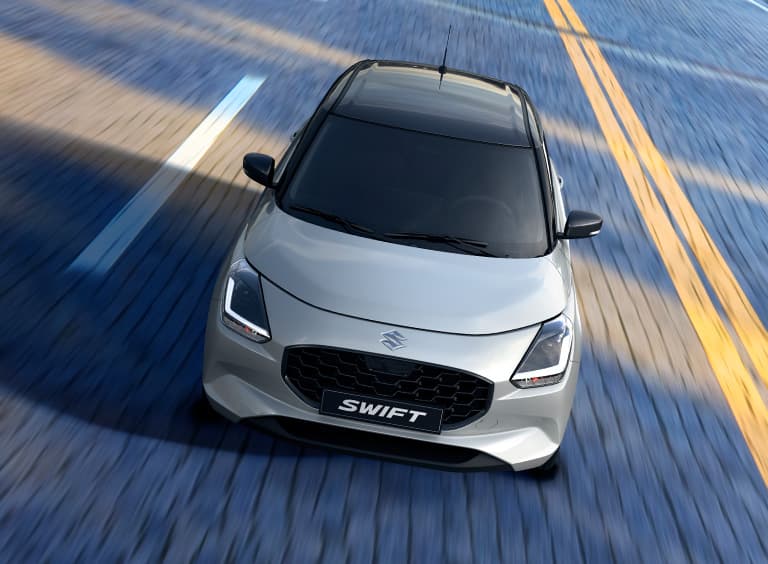 Gleccserfehér és ásványszürke metál Suzuki Swift utcai környezetben