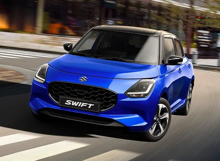 Zafírkék Suzuki Swift városi utcán, gyalogátkelőhelynél
