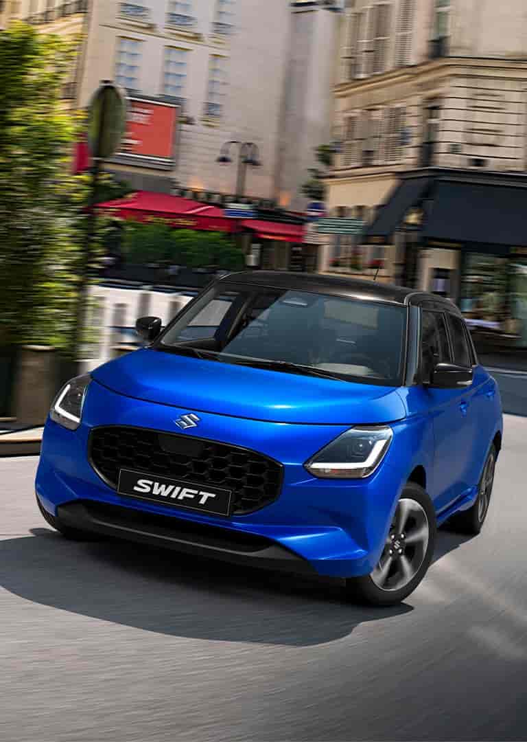 Zafírkék Suzuki Swift parkol egy forgalmas városi utcában